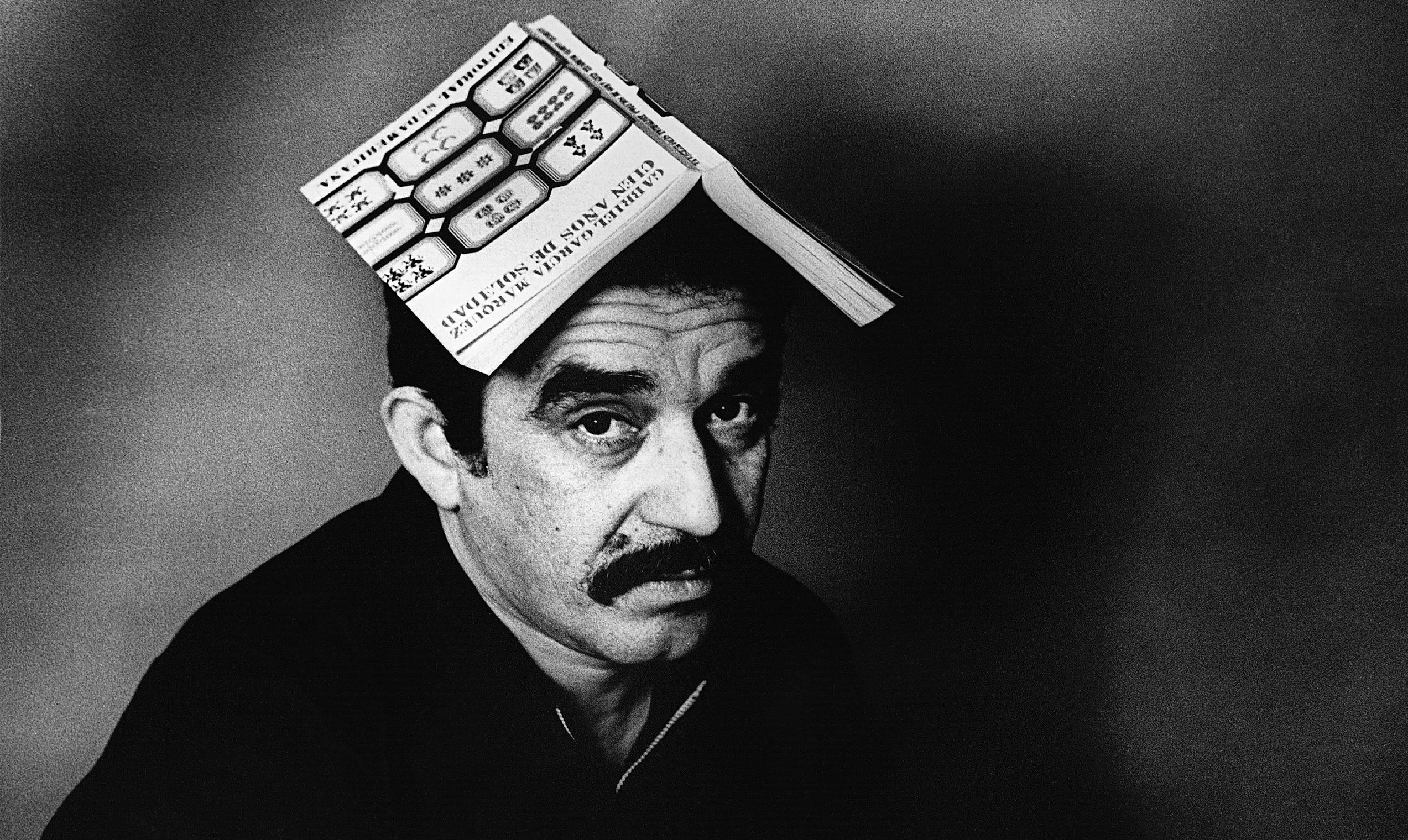 Gabriel García Marquéz with a copy of One Hundred Years of Solitude on his head