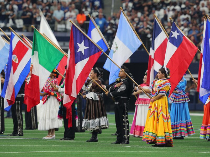 ARLINGTON, TEXAS - OCTOBER 10: Flags are displayed during the national anthem in honor of Hispanic Heritage Month before the game between the Dallas Cowboys and New York Giants at AT&T Stadium on October 10, 2021 in Arlington, Texas.