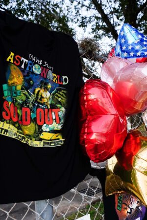 HOUSTON, TX - NOVEMBER 07: A t-shirt and balloons are placed at a memorial outside of the canceled Astroworld festival at NRG Park on November 7, 2021 in Houston, Texas. According to authorities, eight people died and 17 people were transported to local hospitals after what was described as a crowd surge at the Astroworld festival, a music festival started by Houston-native rapper and musician Travis Scott in 2018.