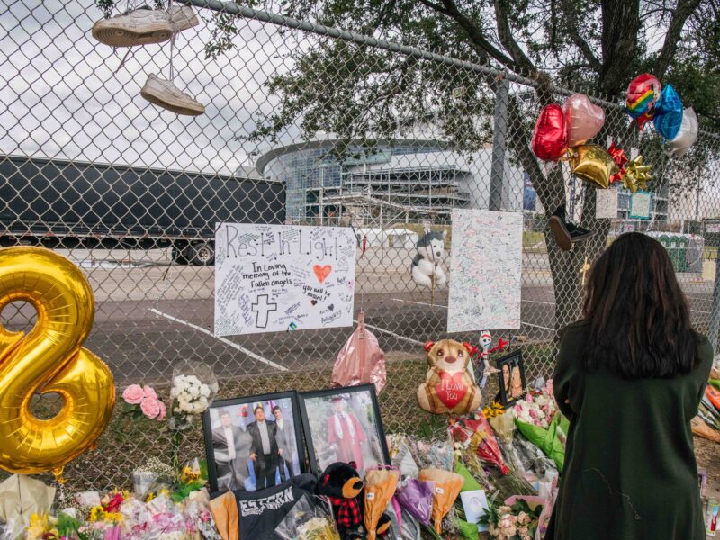 HOUSTON, TEXAS - NOVEMBER 09: A woman views a memorial dedicated to those who died at the Astroworld festival outside of NRG Park on November 09, 2021 in Houston, Texas. Eight people were killed and dozens injured last Friday in a crowd surge during a Travis Scott concert at the Astroworld music festival. Several lawsuits have been filed against Scott, and authorities continue investigations around the event. Scott, a Houston-native rapper and musician, launched the festival in 2018.