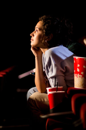 Young woman enjoying watching movie at the cinema