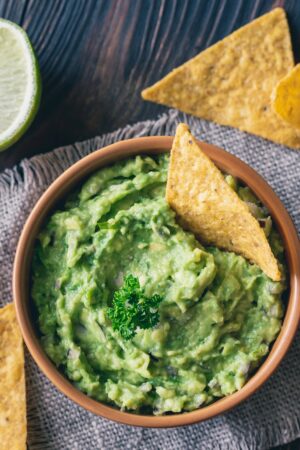 Bowl of guacamole with tortilla chips - stock photo