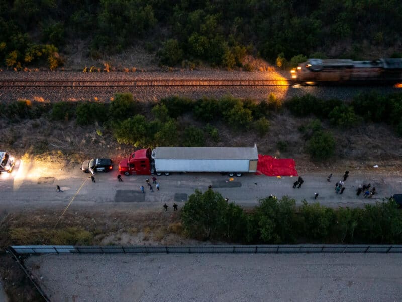 SAN ANTONIO, TX - JUNE 27: In this aerial view, members of law enforcement investigate a tractor trailer on June 27, 2022 in San Antonio, Texas. According to reports, at least 46 people, who are believed migrant workers from Mexico, were found dead in an abandoned tractor trailer. Over a dozen victims were found alive, suffering from heat stroke and taken to local hospitals. (Photo by Jordan Vonderhaar/Getty Images)