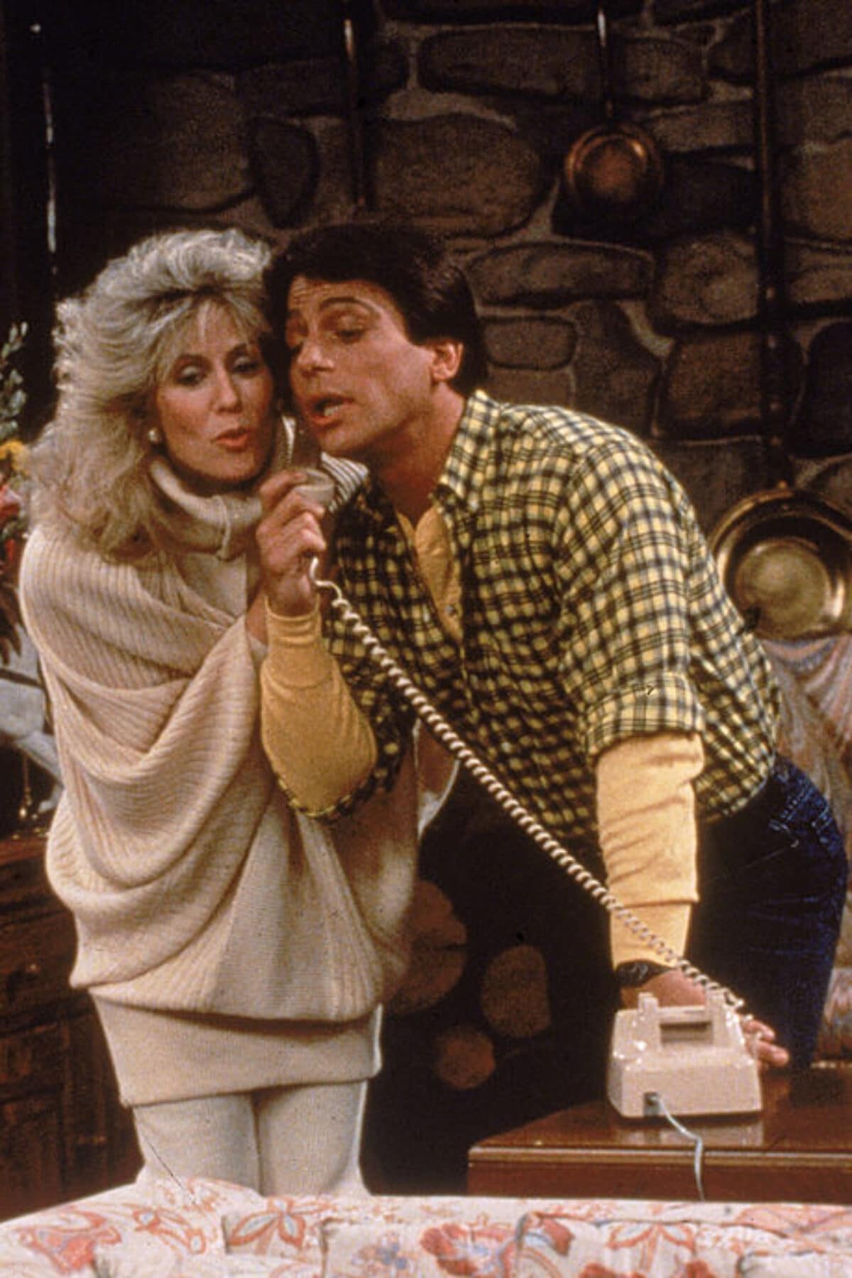 Actor Tony Danza eavesdrops as Judith Light speaks on the telephone, in a still from the TV series, 'Who's The Boss,' circa 1986. (Photo by ABC Television/Fotos International/Getty Images)