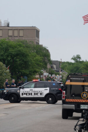 Officers guard the scene of the Fourth of July parade shooting in Highland Park, Illinois on July 4, 2022. - A shooter opened fire Monday during a parade to mark US Independence Day in the state of Illinois, killing at least six people, officials said. "At this time, two dozen people have been transported to Highland Park hospital. Six are confirmed deceased," Commander Chris O'Neil of the city's police told journalists. The suspected shooter, who is still at large, has been described as a white male aged 18-20 with longer black hair, O'Neil said. (Photo by Youngrae Kim / AFP) (Photo by YOUNGRAE KIM/AFP via Getty Images)