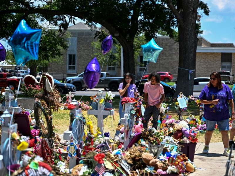People visit a makeshift memorial to the victims of a shooting at Robb Elementary School outside the Uvalde County Courthouse in Uvalde, Texas, on June 30, 2022. - Nineteen young children and two teachers were killed when a teenage gunman went on a rampage at Robb Elementary on May 24 in America's worst school shooting in a decade. (Photo by CHANDAN KHANNA / AFP) (Photo by CHANDAN KHANNA/AFP via Getty Images)