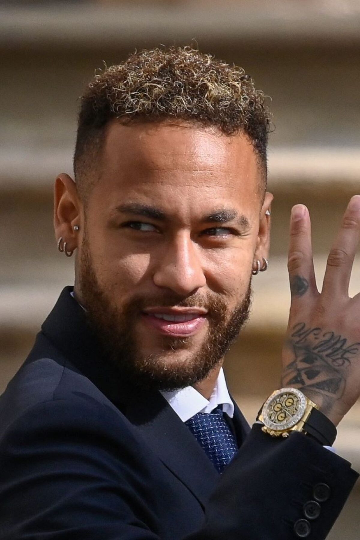TOPSHOT - Paris Saint-Germain's Brazilian forward Neymar gestures as he leaves after attending a hearing at the courthouse in Barcelona on October 18, 2022, on the second day of his trial. - Brazil superstar Neymar said his manager father always handled his contracts as he took the stand at his trial over alleged irregularities in his transfer to Barcelona in 2013. He also said he did not remember if he took part in the negotiations which led to an agreement sealed in 2011 with Barcelona over his transfer two years later to the Catalan side from Brazilian club Santos. (Photo by Josep LAGO / AFP) (Photo by JOSEP LAGO/AFP via Getty Images)