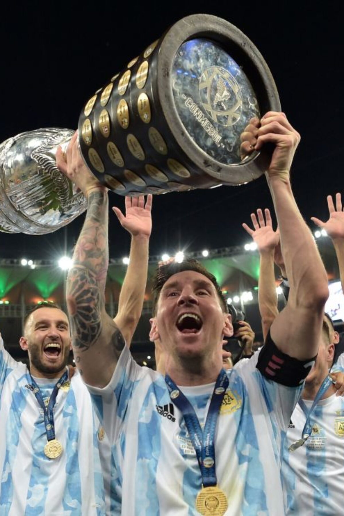TOPSHOT - Argentina's Lionel Messi holds the trophy as he celebrates with teammates after winning the Conmebol 2021 Copa America football tournament final match against Brazil at Maracana Stadium in Rio de Janeiro, Brazil, on July 10, 2021. - Argentina won 1-0. (Photo by CARL DE SOUZA / AFP) (Photo by CARL DE SOUZA/AFP via Getty Images)