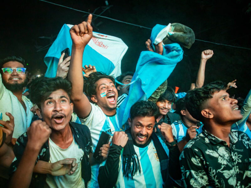 Football fans in Bangladesh celebrate after Argentina players scored a goal as they watch the Qatar 2022 World Cup Group C football match between Argentina and Poland on a big screen, the Dhaka University area, on December 1, 2022.