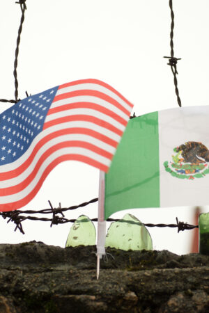 U.S. and Mexico border wall with flags