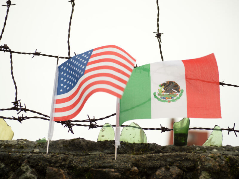U.S. and Mexico border wall with flags