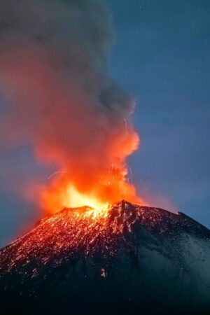 Incandescent materials, ash and smoke are spewed from the Popocatepetl volcano as seen from thr Santiago Xalitzintla community, state of Puebla, Mexico, on May 22, 2023. Mexican authorities on May 21 raised the warning level for the Popocatepetl volcano to one step below red alert, as smoke, ash and molten rock spewed into the sky posing risks to aviation and far-flung communities below. Sunday's increased alert level -- to "yellow phase three" -- comes a day after two Mexico City airports temporarily halted operations due to falling ash. (Photo by Erik GOMEZ TOCHIMANI / AFP) (Photo by ERIK GOMEZ TOCHIMANI/AFP via Getty Images)