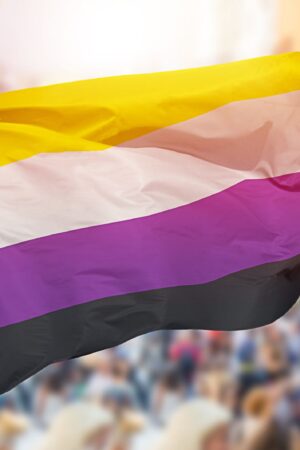 Shot of a non-binary pride flag blowing in the wind at street