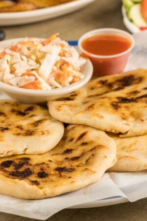 A dish of pupusas and others mexican food on the table - stock photo
