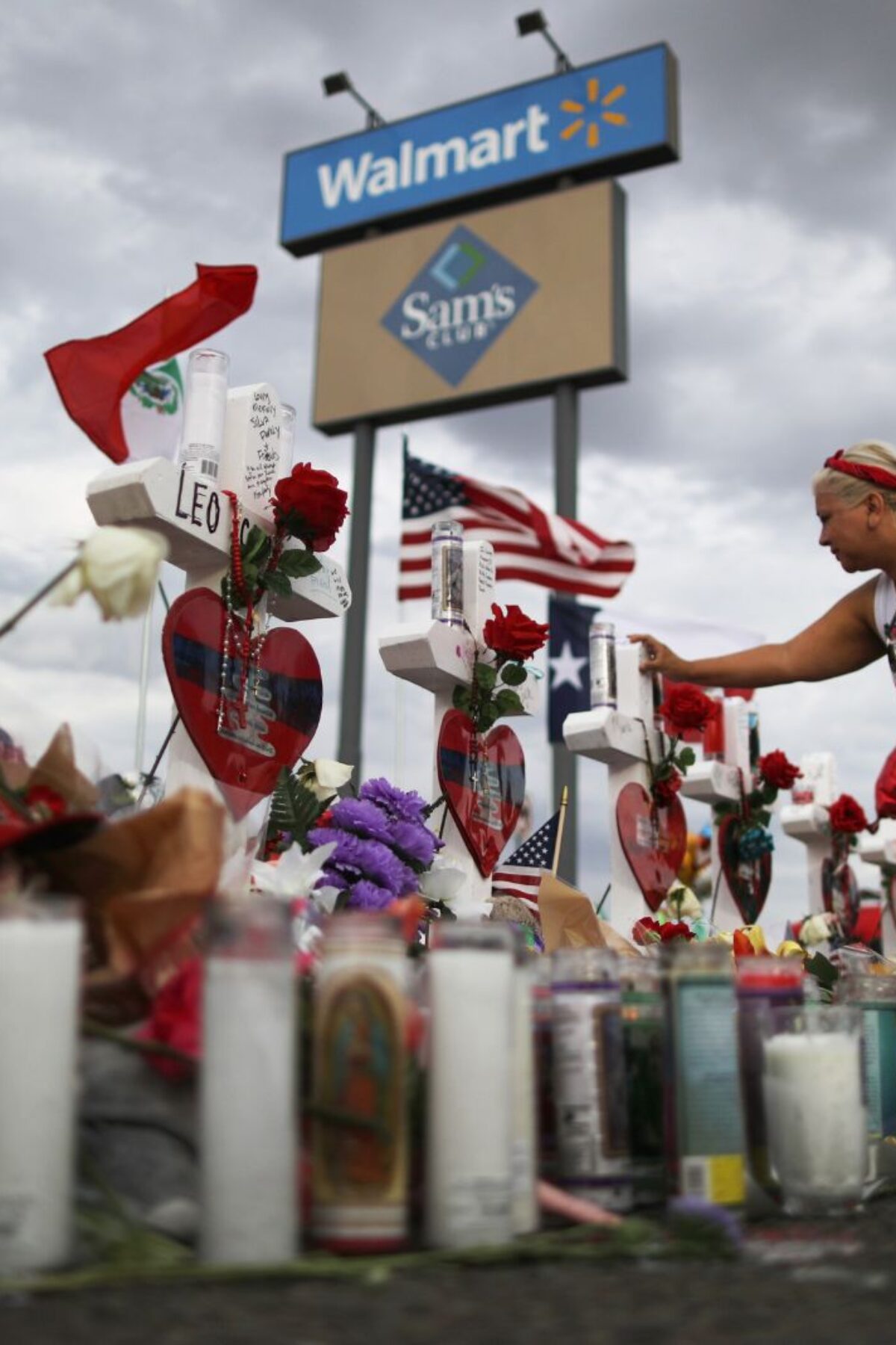 EL PASO, TEXAS - AUGUST 06: A woman touches a cross at a makeshift memorial for victims outside Walmart, near the scene of a mass shooting which left at least 22 people dead, on August 6, 2019 in El Paso, Texas. A 21-year-old white male suspect remains in custody in El Paso, which sits along the U.S.-Mexico border. President Donald Trump plans to visit the city August 7. (Photo by Mario Tama/Getty Images)