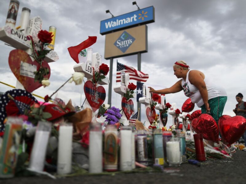 EL PASO, TEXAS - AUGUST 06: A woman touches a cross at a makeshift memorial for victims outside Walmart, near the scene of a mass shooting which left at least 22 people dead, on August 6, 2019 in El Paso, Texas. A 21-year-old white male suspect remains in custody in El Paso, which sits along the U.S.-Mexico border. President Donald Trump plans to visit the city August 7. (Photo by Mario Tama/Getty Images)