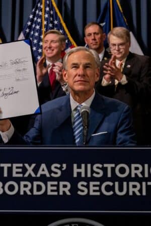 AUSTIN, TEXAS - JUNE 08: Texas Gov. Greg Abbott displays a signed bill during a news conference on June 08, 2023 in Austin, Texas. Gov. Abbott and Texas Department of Public Safety Director Steve McCraw joined bill authors, sponsors, legislators and law enforcement members in the signing of bills designated towards enhancing border security along the southern border. (Photo by Brandon Bell/Getty Images)