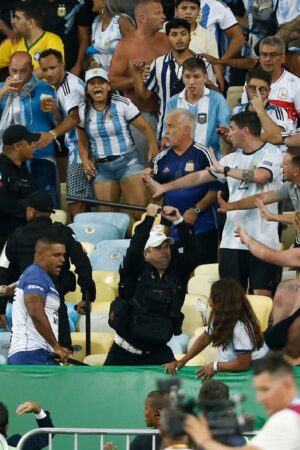 RIO DE JANEIRO, BRAZIL - NOVEMBER 21: Police officers armed with batons clash with fans as the match is delayed due to the incidents prior to a FIFA World Cup 2026 Qualifier match between Brazil and Argentina at Maracana Stadium on November 21, 2023 in Rio de Janeiro, Brazil. (Photo by Wagner Meier/Getty Images)