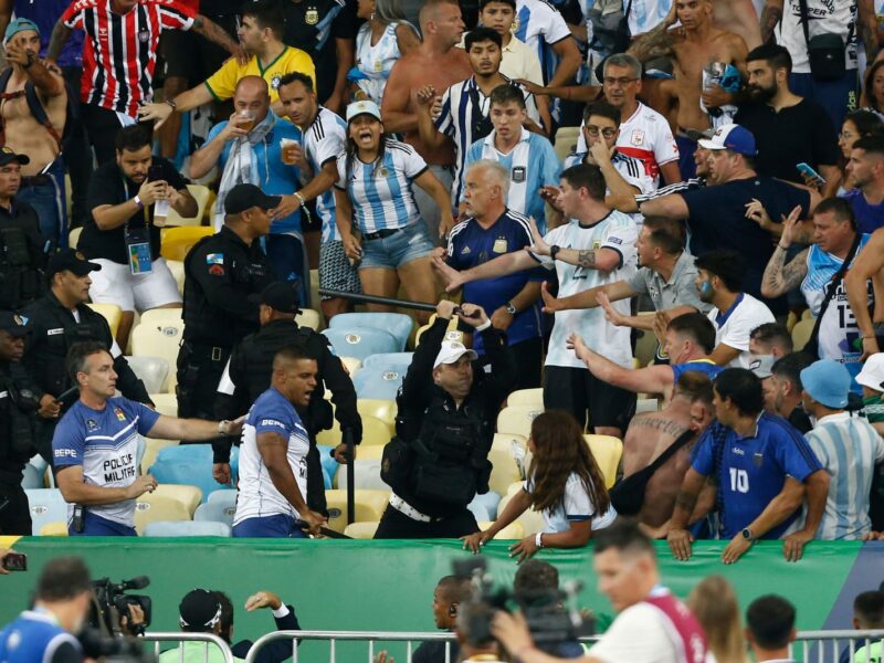 RIO DE JANEIRO, BRAZIL - NOVEMBER 21: Police officers armed with batons clash with fans as the match is delayed due to the incidents prior to a FIFA World Cup 2026 Qualifier match between Brazil and Argentina at Maracana Stadium on November 21, 2023 in Rio de Janeiro, Brazil. (Photo by Wagner Meier/Getty Images)