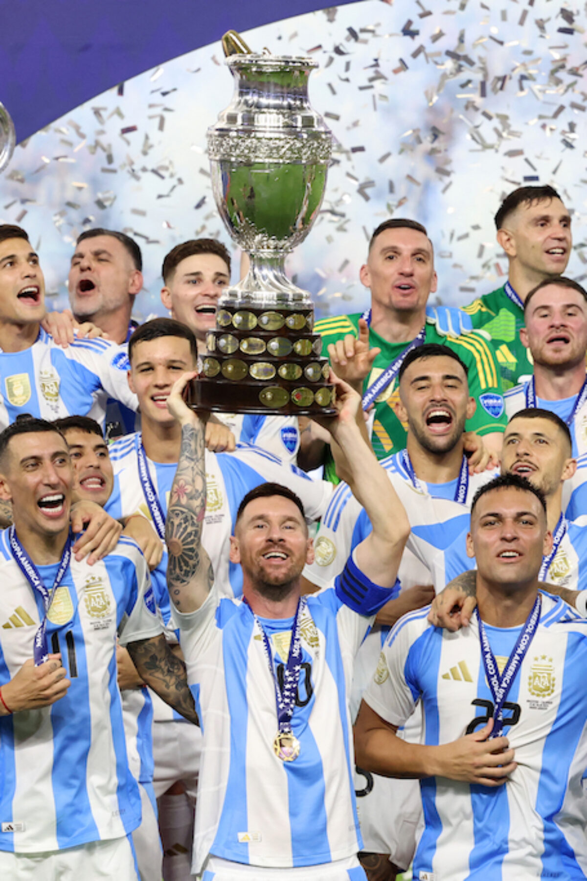 Argentina's forward #10 Lionel Messi lifts up the trophy.