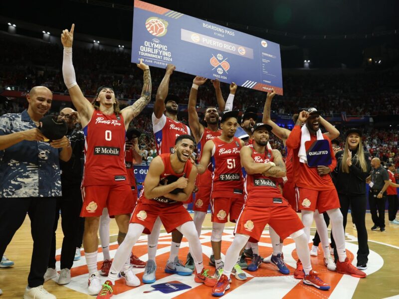 Puerto Rico's players celebrate with the ticket to the 2024 Paris Olympics after defeating Lithuania during the 2024 FIBA Men's Olympic Qualifying Tournament basketball match in San Juan, Puerto Rico, on July 7, 2024. (Photo by Ricardo ARDUENGO / AFP) (Photo by RICARDO ARDUENGO/AFP via Getty Images)