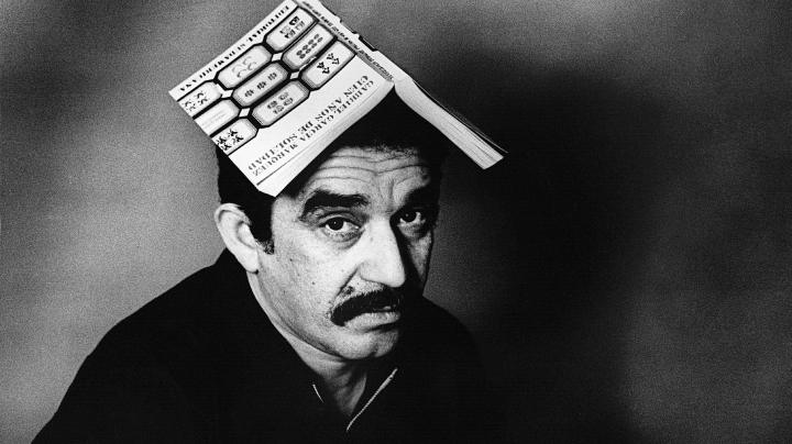 Gabriel García Marquéz with a copy of One Hundred Years of Solitude on his head