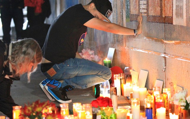 Family and friends of Antonio Ramos grieve during a vigil at the site of the mural project in Oakland, Calif., on Wednesday, Sept. 30, 2015, where Ramos was shot and killed. (Laura A. Oda/Bay Area News Group)