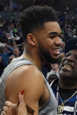 Karl-Anthony Towns #32 of the Minnesota Timberwolves hugs his parents, Karl and Jackie Towns after winning the game against the Denver Nuggets. Photo by Hannah Foslien/Getty Images