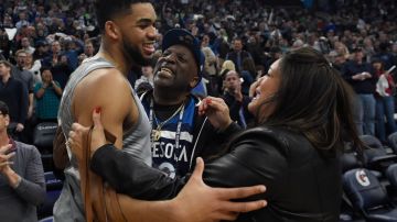 Karl-Anthony Towns #32 of the Minnesota Timberwolves hugs his parents, Karl and Jackie Towns after winning the game against the Denver Nuggets. Photo by Hannah Foslien/Getty Images