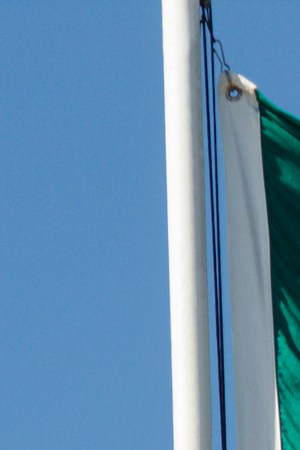 Mexican Flag, National Banner of Mexico Waving Against Blue Sky