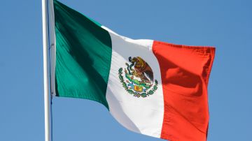 Mexican Flag, National Banner of Mexico Waving Against Blue Sky