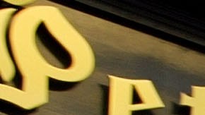 People walk past the Peter Luger steakhouse December 29, 2003 in New York City. Photo by Spencer Platt/Getty Images News