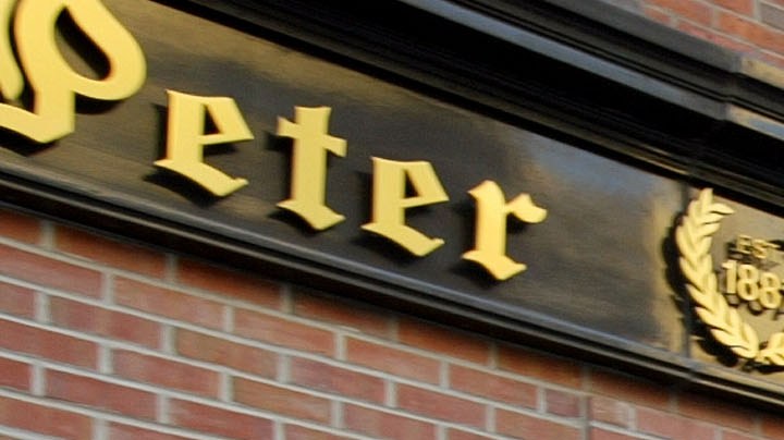 People walk past the Peter Luger steakhouse December 29, 2003 in New York City. Photo by Spencer Platt/Getty Images News
