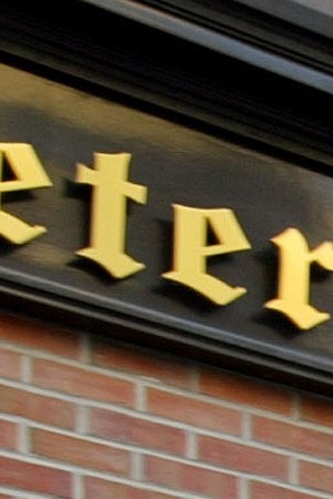 People walk past the Peter Luger steakhouse December 29, 2003 in New York City. Photo by Spencer Platt/Getty Images News