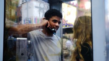 Jerome Farah stands in a repurposed telephone booth in Times Square listening to artist Aman Mojadidi interactive public art installation 'Once Upon a Place' on June 27, 2017 in New York City. Photo by Spencer Platt/Getty Images News