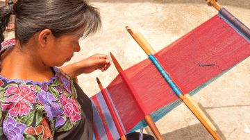 Indigenous Tzotzil women weaving a traditional Huipil at the loom. San Lorenzo Zinacantan is a small village in the southern part of the Central Chiapas highlands in the Mexican state of Chiapas.