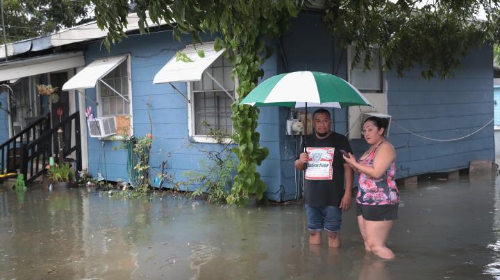 Vincente Navas (L) and Alma Barrientos stand outside their home in the Cottage Grove neighborhood which has been inundated with floodingf from Hurricane Harvey on August 27, 2017 in Houston, Texas. Photo by Scott Olson/Getty Images News
