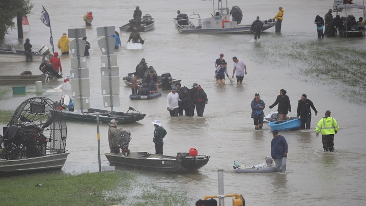People walk down a flooded street as they evacuate their homes after the area was inundated with flooding from Hurricane Harvey on August 28, 2017 in Houston, Texas. Harvey, which made landfall north of Corpus Christi late Friday evening, is expected to dump upwards to 40 inches of rain in Texas over the next couple of days. Photo by Joe Raedle/Getty Images
