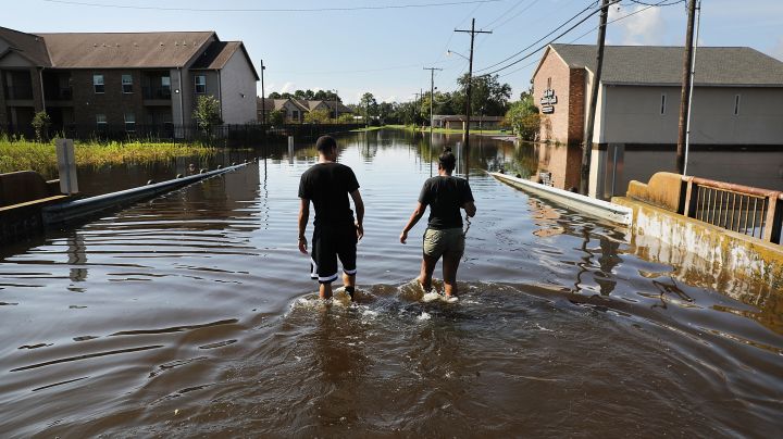 A couple walk through their flooded neighborhood as Texas slowly moves toward recovery from the devastation of Hurricane Harvey. Photo by Spencer Platt/Getty Images News