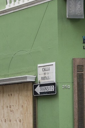 A woman passes a boarded up business as residents prepare for a direct hit from Hurricane Maria on September 19, 2017 in San Juan, Puerto Rico. Photo by Alex Wroblewski/Getty Images News
