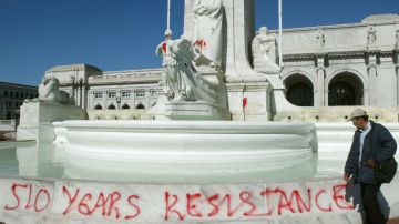 A man walks past a statue of Christopher Columbus that was vandalized with red paint at Union Station October 14, 2002 in Washington, D.C. Photo by Mark Wilson/Getty Images News