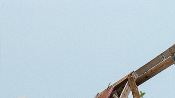 Lidybel Águila and Anabelle pose in front of the remains of their of a wooden house that used to have their favorite mural in the town of Arecibo. Photo by Stephanie Segarra for Remezcla