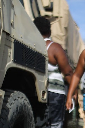 A resident carries food and water, provided by FEMA, in a neighborhood without grid electricity or running water on October 17, 2017 in San Isidro, Puerto Rico. Photo by Mario Tama/Getty Images