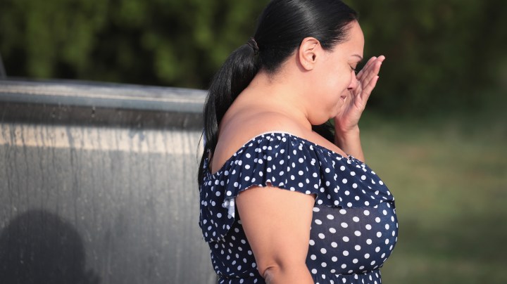 Meredeth Cooper wipes away a tear after handing flowers to a police officer guarding a road block near the First Baptist Church of Sutherland Springs. Photo by Scott Olson/Getty Images News