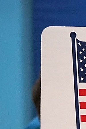 Karina Smith holds her 2-year-old son Kyler as she fills out her ballot at the polling place at Washington Mill Elementary School. Photo by Chip Somodevilla/Getty Images News