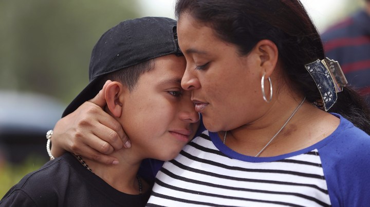 Jenny Martinez hugs her son, William Martinez, as they talk to the media about her trip from El Salvador and her need for asylum in America because of domestic violence and her fear for her life as they join with protesters in front of the United States Citizenship and Immigration Services building.  Photo by Joe Raedle/Getty Images