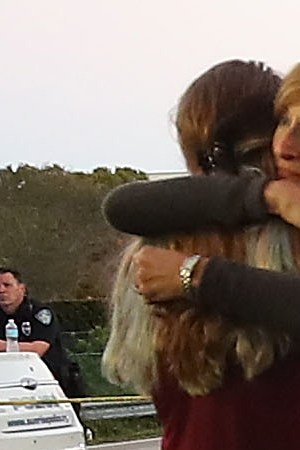 Kristi Gilroy (R), hugs a young woman at a police check point near the Marjory Stoneman Douglas High School where 17 people were killed by a gunman yesterday, on February 15, 2018 in Parkland, Florida. Police arrested the suspect after a short manhunt, and have identified him as 19-year-old former student Nikolas Cruz.  Photo by Mark Wilson/Getty Images