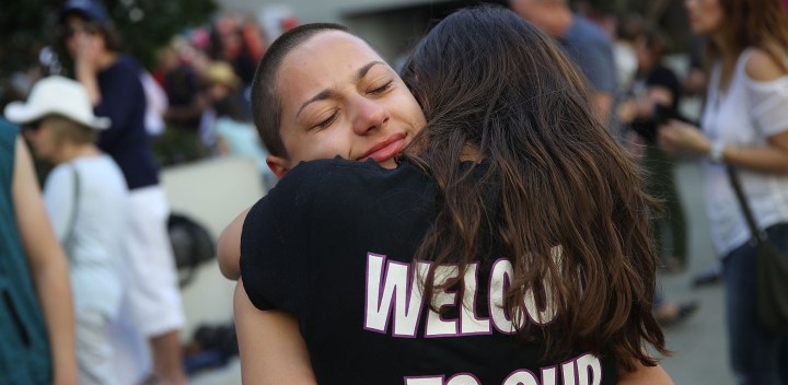 Emma Gonzalez is hugged as she joins other people after a school shooting that killed 17 to protest against guns on the steps of the Broward County Federal courthouse. Photo by Joe Raedle/Getty Images