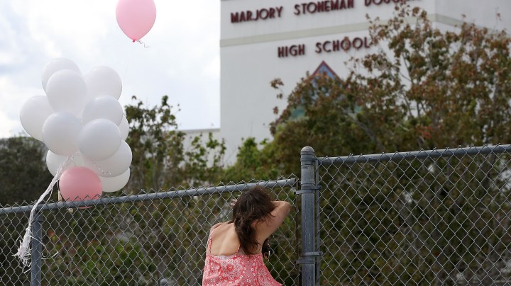 Angela Tanner, rests against the fence that surrounds the Marjory Stoneman Douglas High School. Photo by Mark Wilson/Getty Images