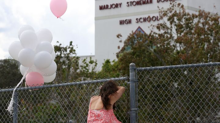 Angela Tanner, rests against the fence that surrounds the Marjory Stoneman Douglas High School. Photo by Mark Wilson/Getty Images